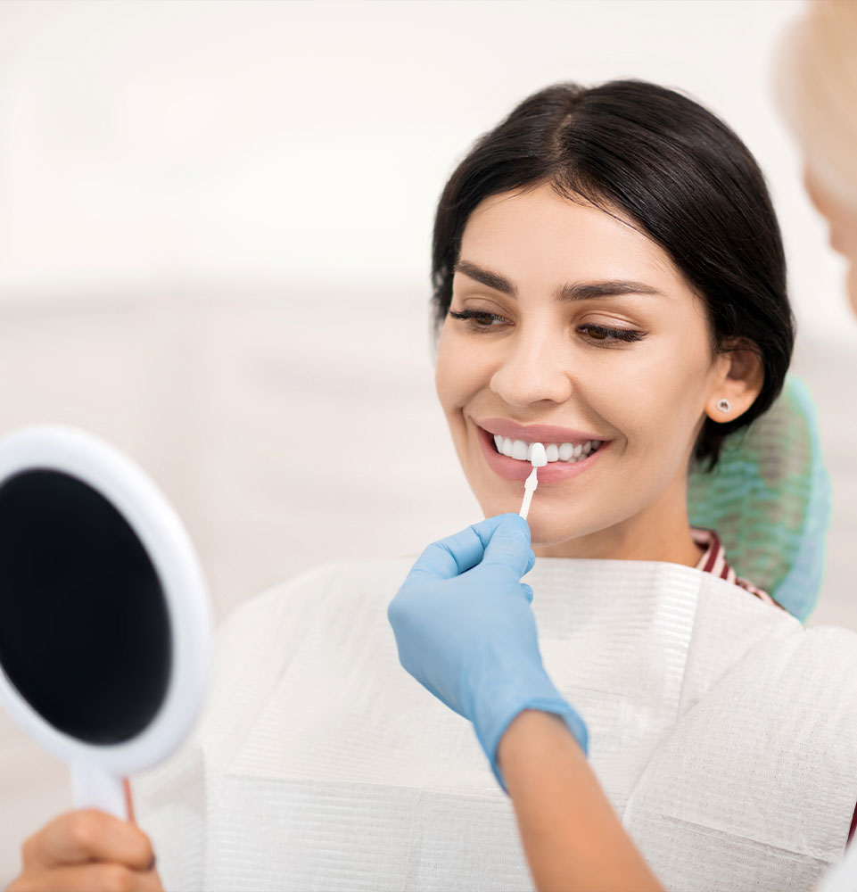 Woman trying on teeth whitening sample at dentists.