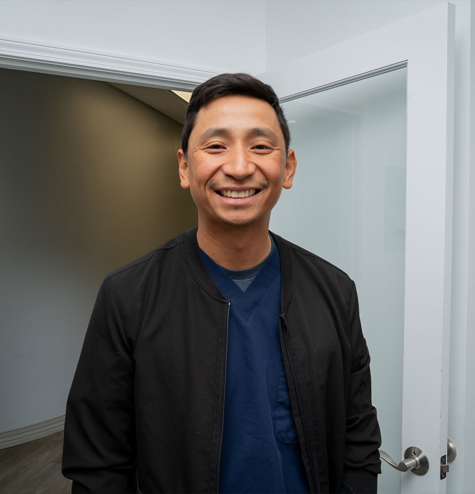 headshot of doctor smiling brightly within the dental center