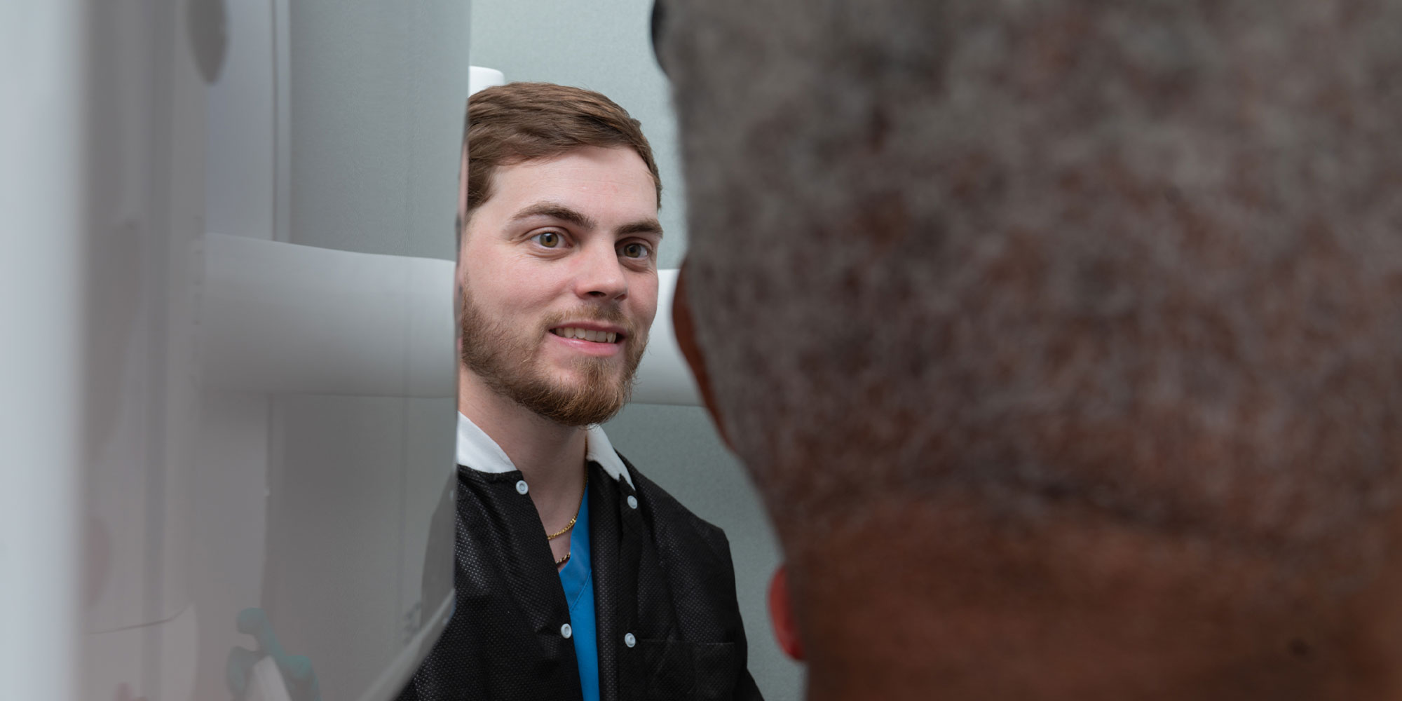 close up of staff member helping patient undergo a cbct scan for dental treatment