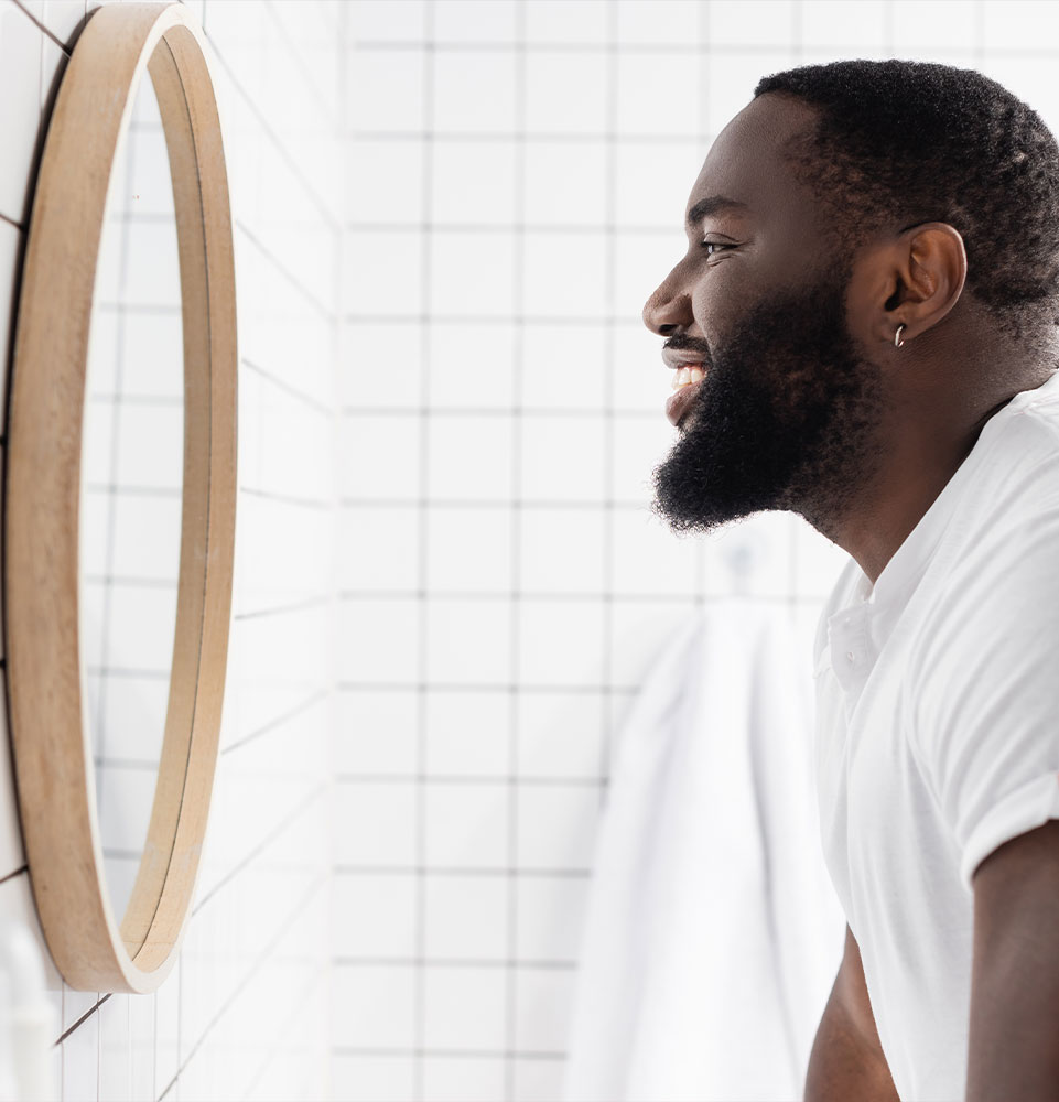 man smiling and looking in mirror