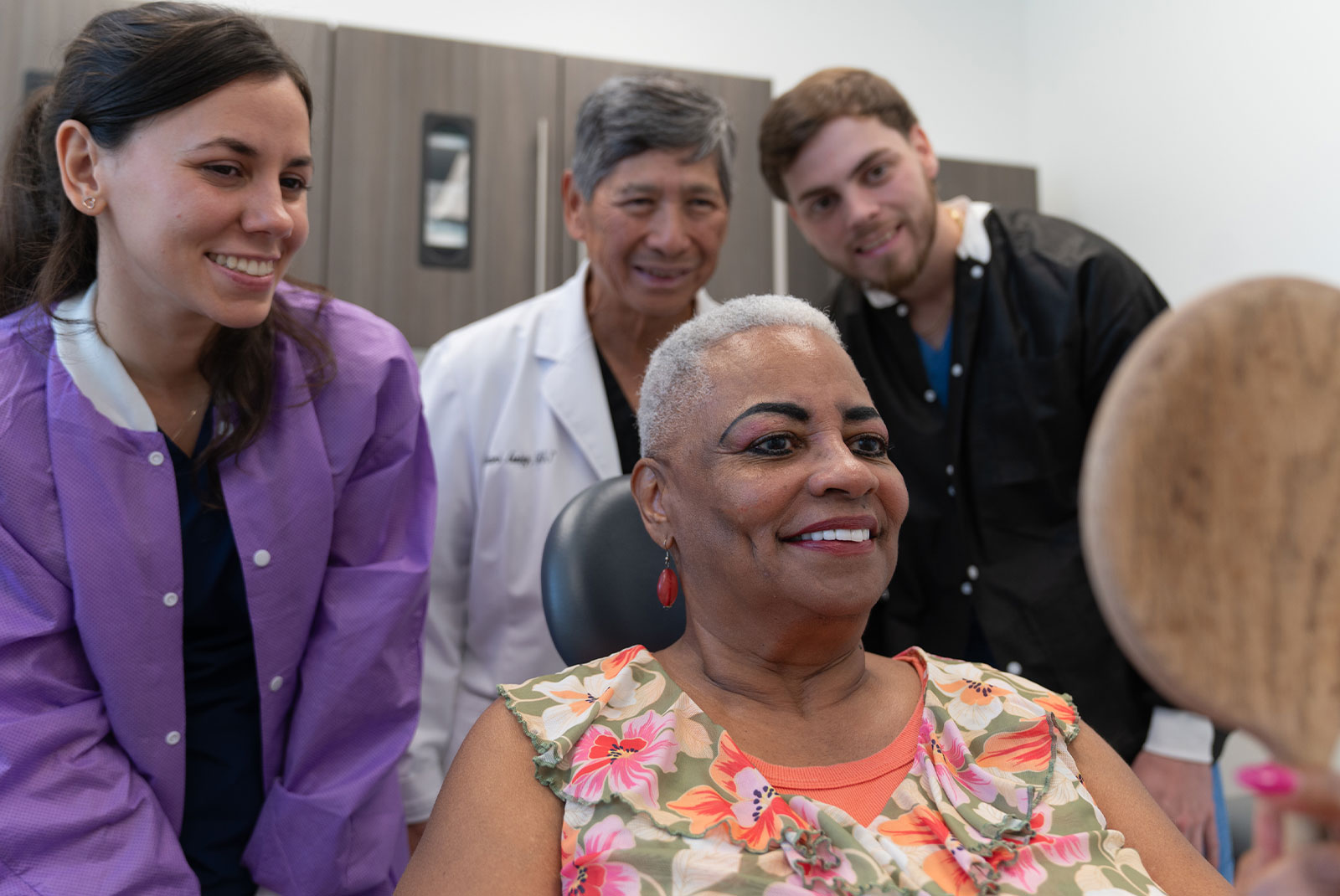 patient and staff members all smiling after patient's dental procedure