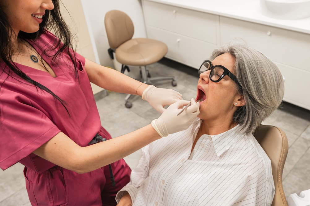 A dentist is consulting with a patient about a dental implant. No text on image.